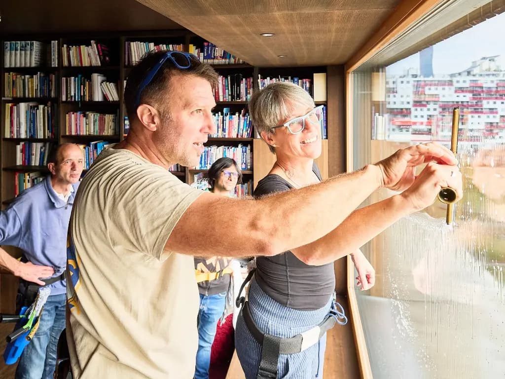 Professional window cleaning training workshop with Justin Orloff demonstrating streak-free squeegee technique